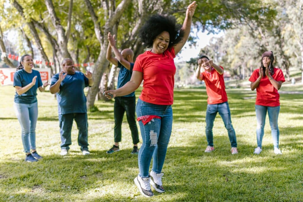Varias personas vestidas con camisetas rojas y azules se encuentran en un parque, disfrutando del aire libre