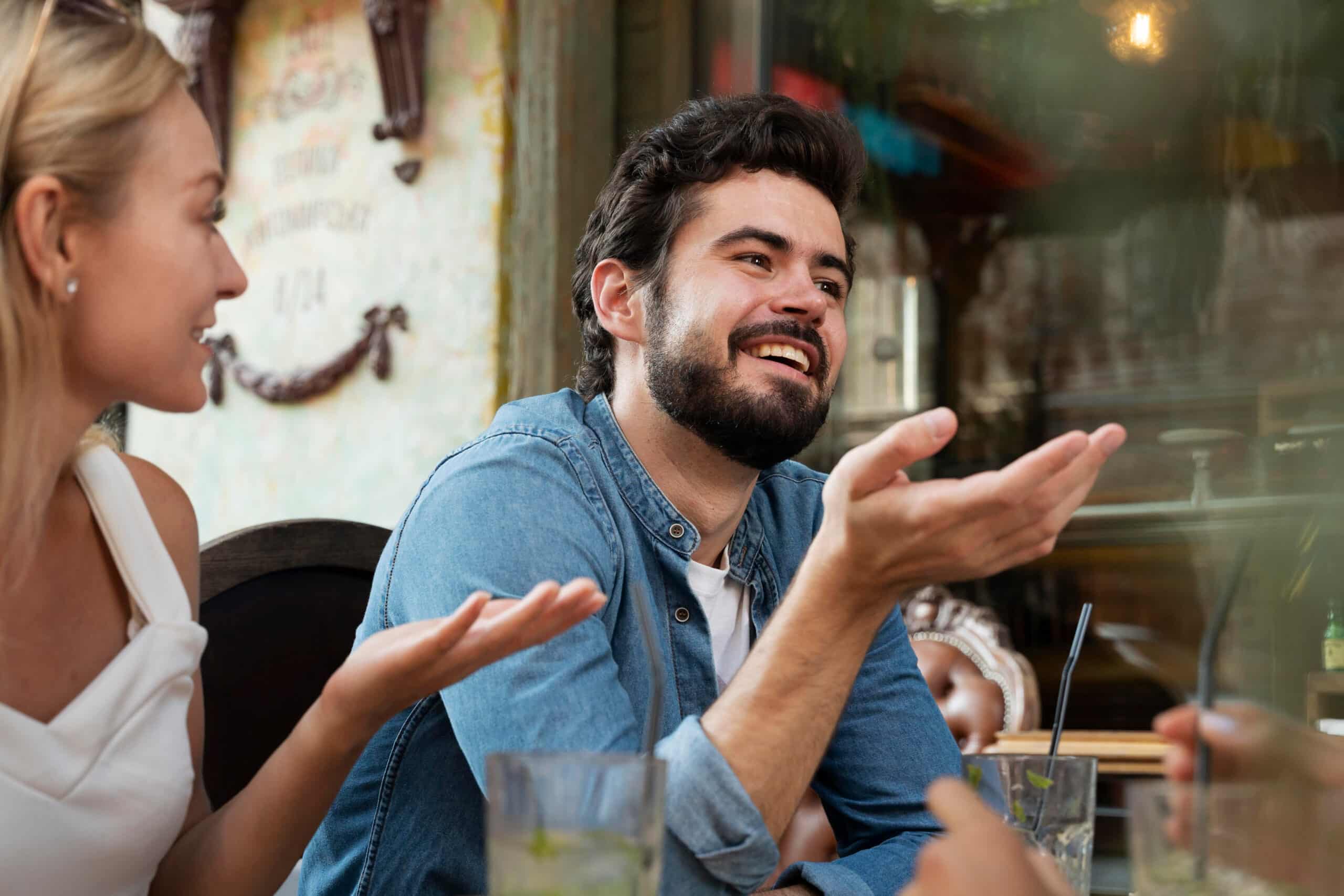 1. Hombre y mujer riendo juntos en una mesa, disfrutando de un momento alegre.